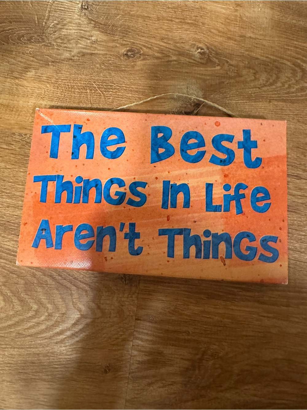the best things in life aren’t things Orange Wall Canvas with Blue Lettering